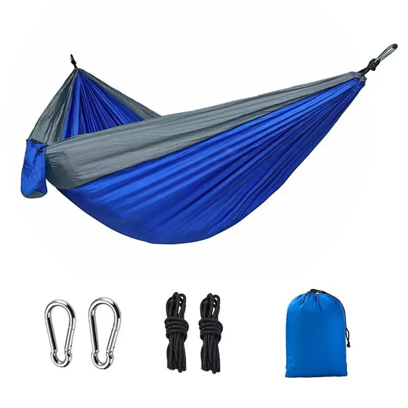 A sapphire blue double-layer nylon hammock hung between two trees, showing its full 270cm length and 140cm width.