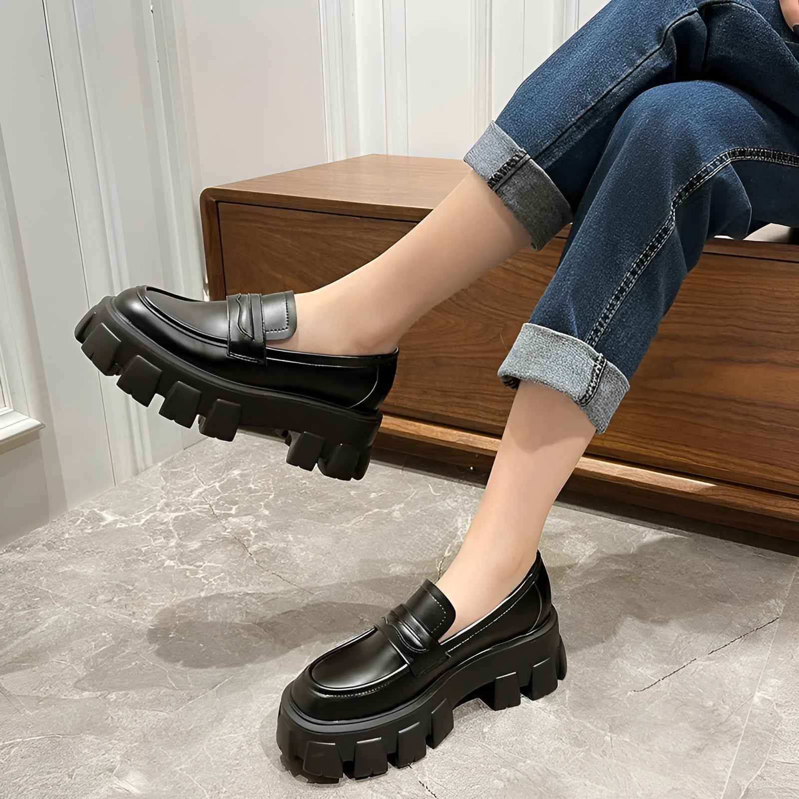 A pair of British style wide fit loafers in either matte or glossy patent leather with a shallow opening and rubber sole.