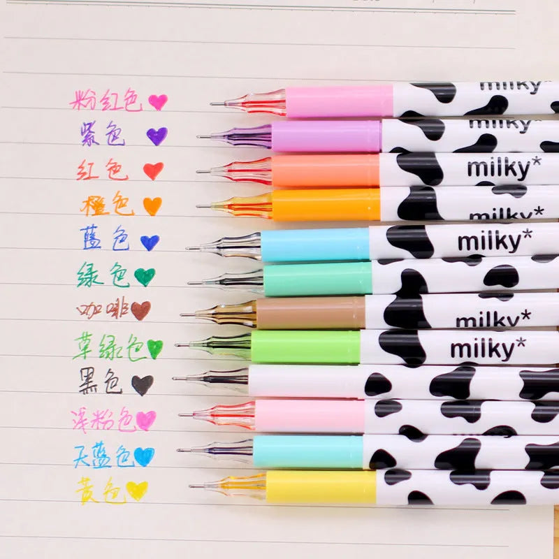 Box of 12 cow print coloured gel pens with 0.38mm fine tips on a desk.