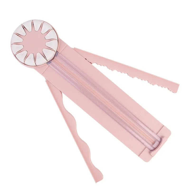 Pink plastic 12-in-1 paper cutting machine with dotted line and other pattern guides on a flat surface.