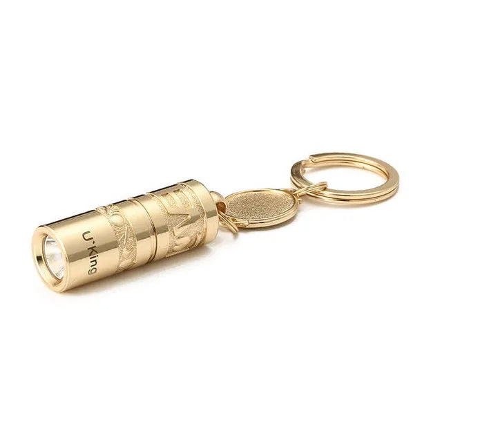 Gold-coloured zinc alloy mini LED flashlight on a keyring for outdoor and emergency use.