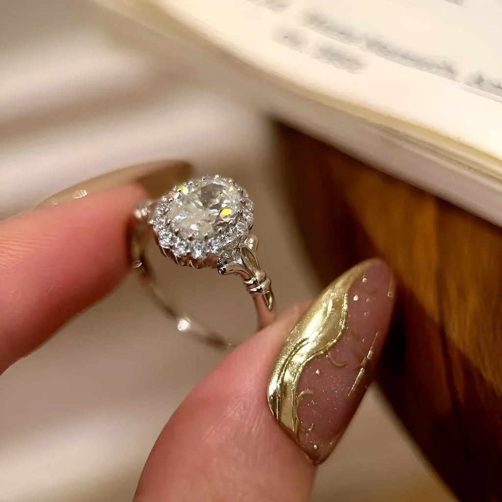 Close-up of a silver women's ring with an adjustable geometric band and a large oval bridal bouquet style diamond cluster.