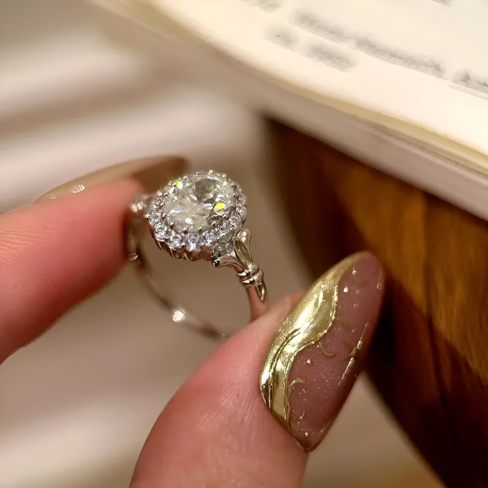 Close-up of a silver women's ring with an adjustable geometric band and a large oval bridal bouquet style diamond cluster.
