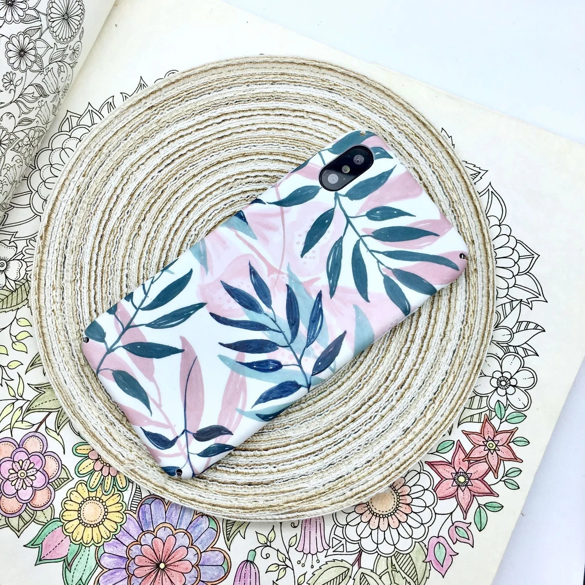Green and pink painted plastic back cover cases for mobile phones on a white background.