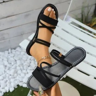 Women's flat sandals with cross strap and flip-toe buckle in black, brown, or green
