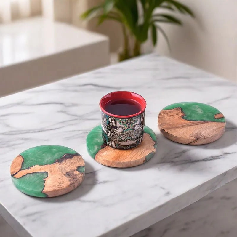 A solid black round resin coaster for a tea set, 9.8cm across and 1cm thick, on a wooden surface.