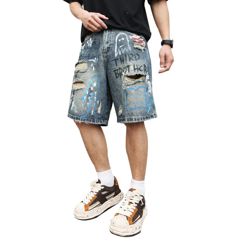 Blue men's ripped denim shorts with graffiti style and straight leg cut on a hanger.