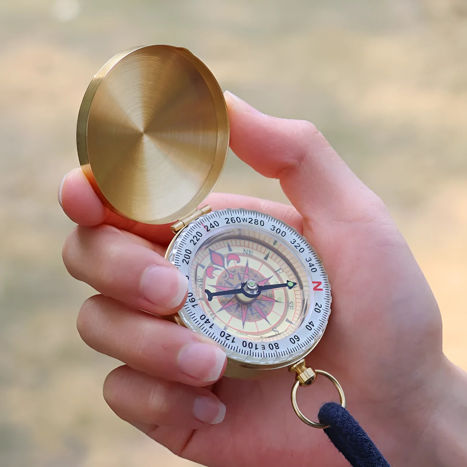 Gold brass flip compass with luminous dial and lid closed, 50mm diameter for outdoor navigation