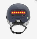 Adult cycling helmet with integrated red LED brake light and tail light on the rear.