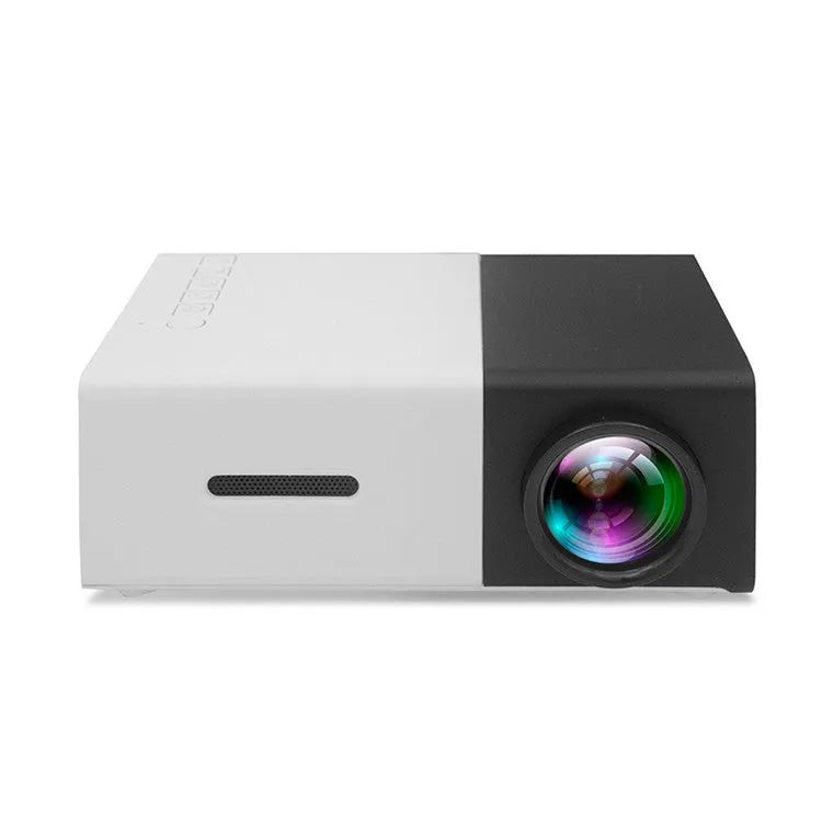 Mini LED projector YG300 in white and yellow, with lens and ventilation grilles, on a table