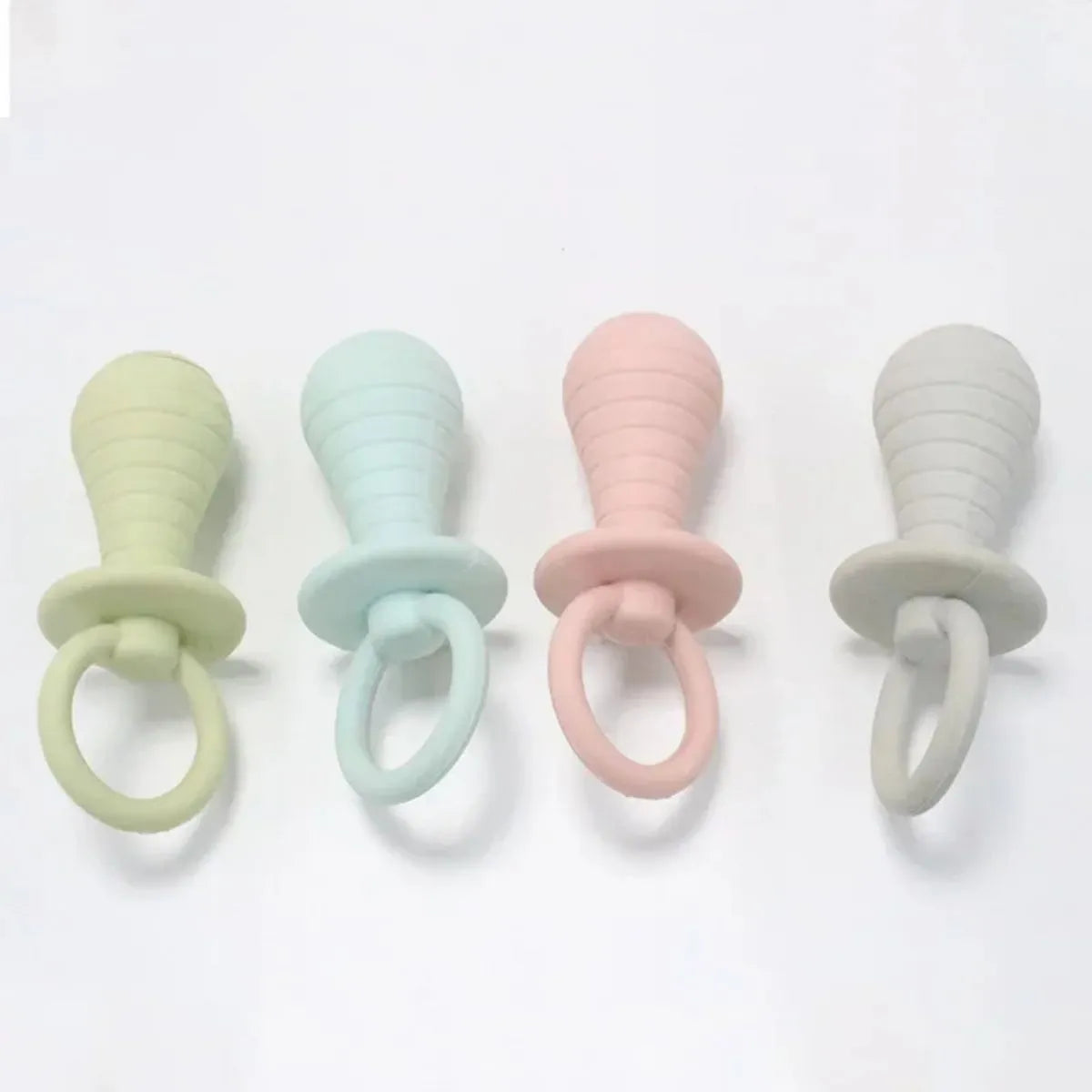 Four coloured TPR rubber pacifier-style pet chew toys with squeakers for puppies and kittens.