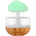 White portable USB humidifier with night light and essential oil diffuser on a wooden surface.