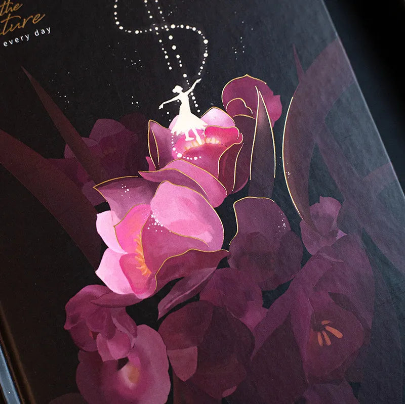 A5 spiral-bound notebook with a luminous coloured cover, open to show lined pages with colour illustrations.