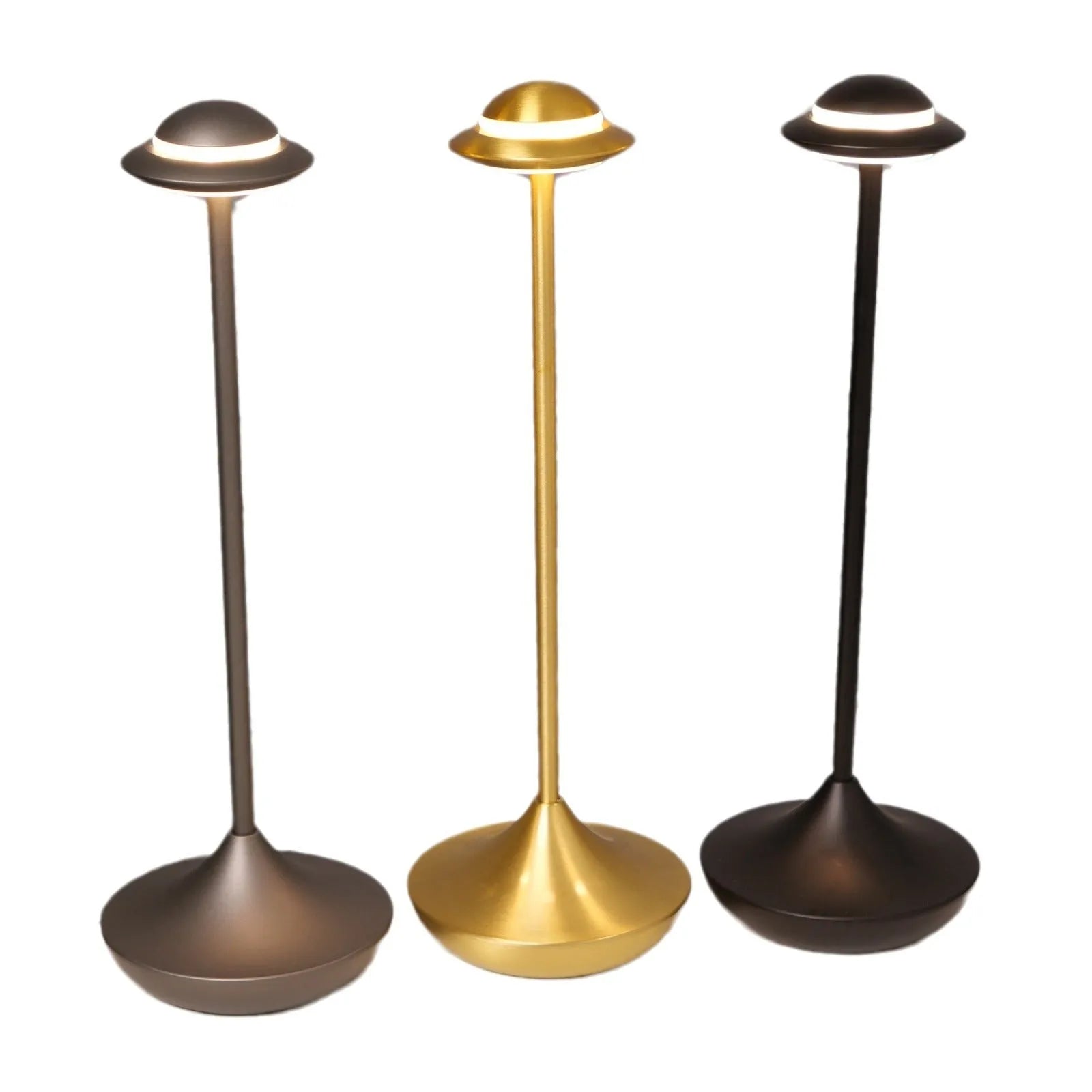 Modern UFO-shaped metal table lamp in black on a wooden desk, showing cord-free design.