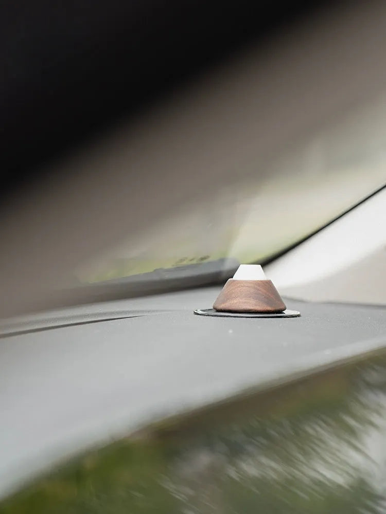 Round solid wood car air freshener with essential oil and anti-slip pad on dashboard