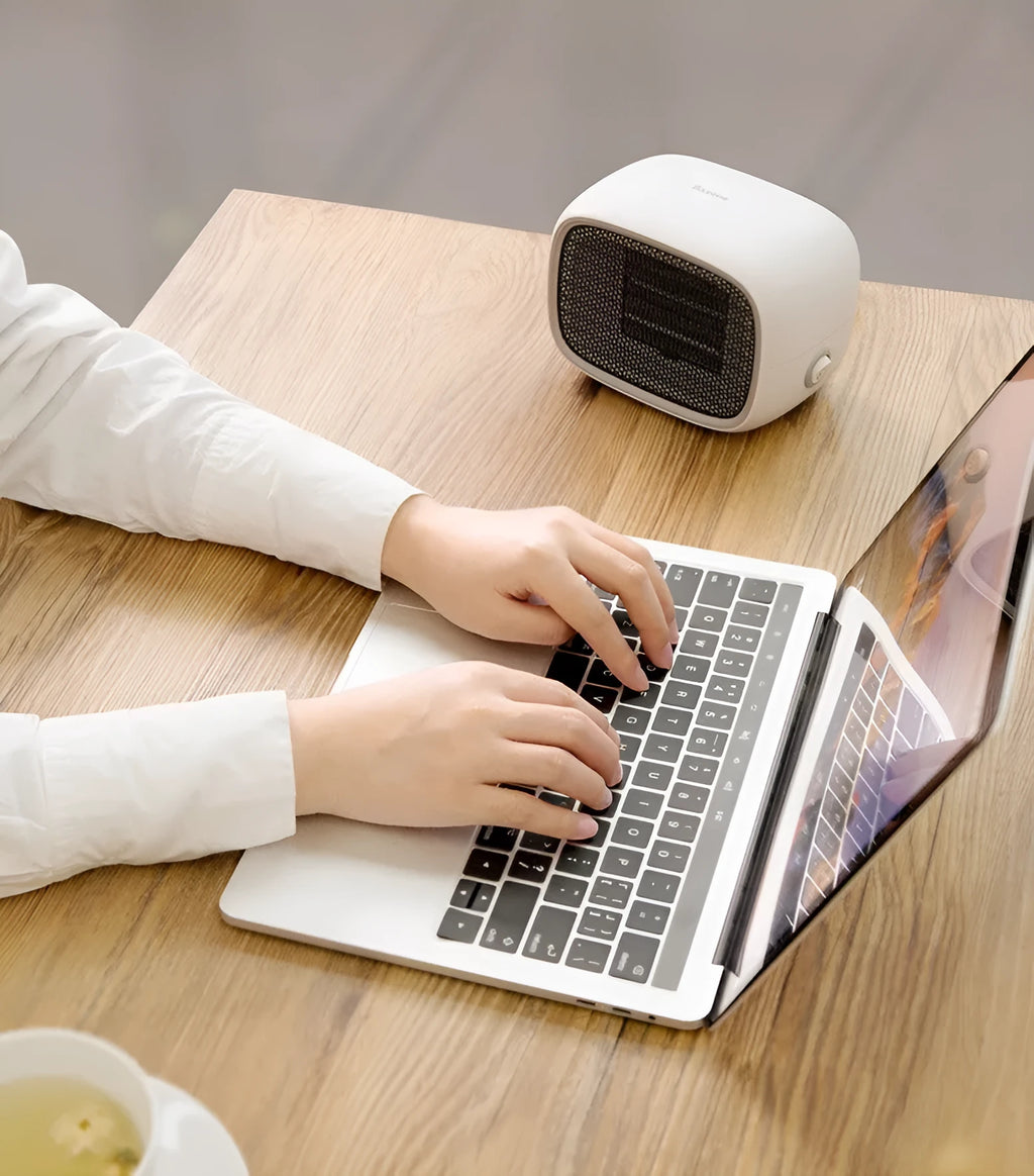 Green mini portable heater with dimensions 158mm x 90mm x 114mm on a wooden desk.
