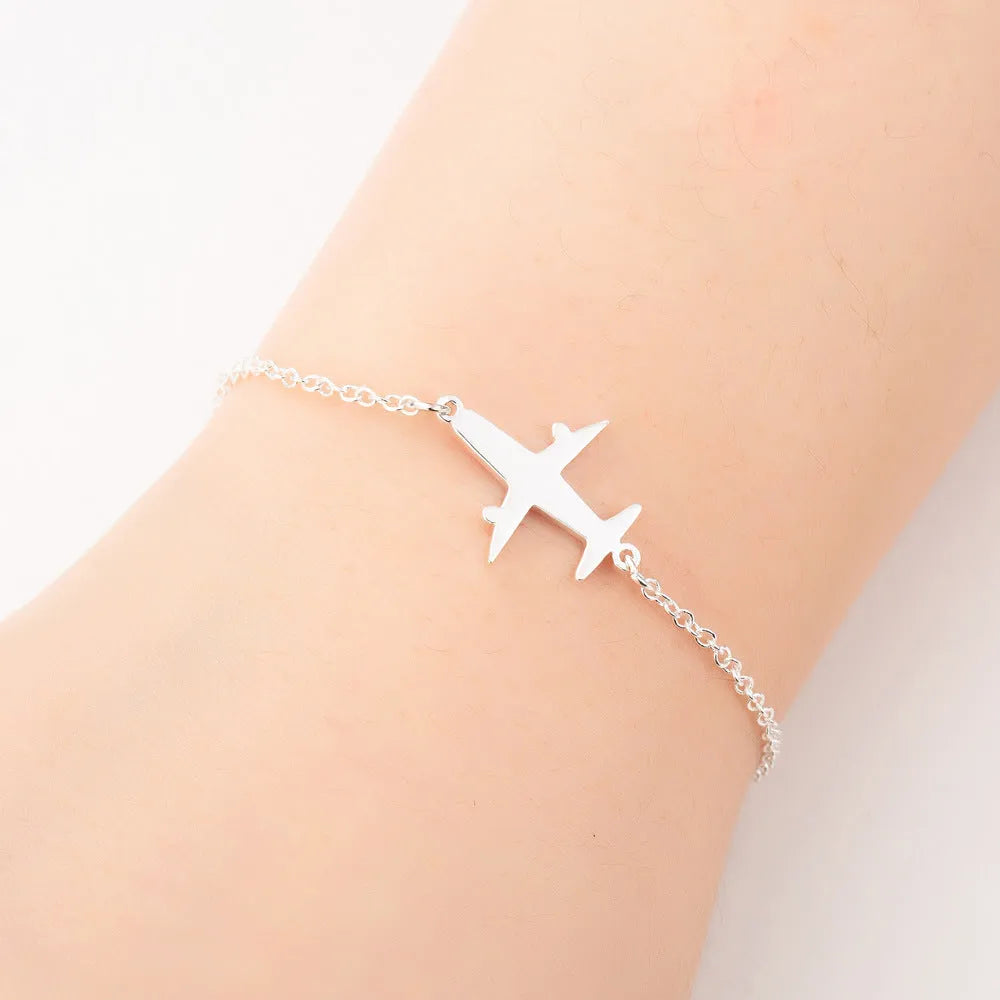 Alloy bracelet with simple airplane pendant in gold colour, unisex style