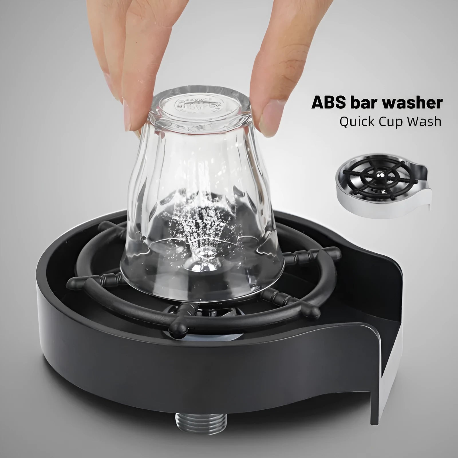 Black automatic cup washer with five-hole nozzle installed on a bar counter sink with a glass being rinsed
