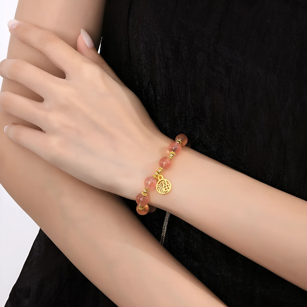 Women's Strawberry Quartz crystal bracelet with geometric shape and fu character design on an electroplated chain.