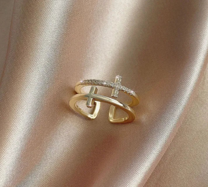 Close-up of a women's adjustable copper ring featuring a miniature double cross design with a zircon stone set in sterling silver.