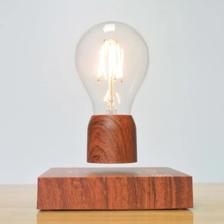 Magnetic levitation desk lamp with a floating glass bulb above an imitation wood base.