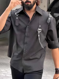Man wearing a black utility-style button-up polyester shirt with a regular fit.