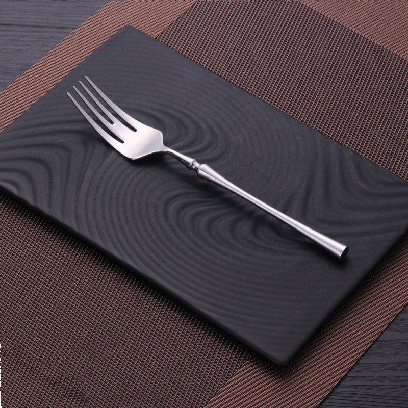 Stainless steel cutlery set with main knife, main fork, main spoon, and teaspoon in silver finish