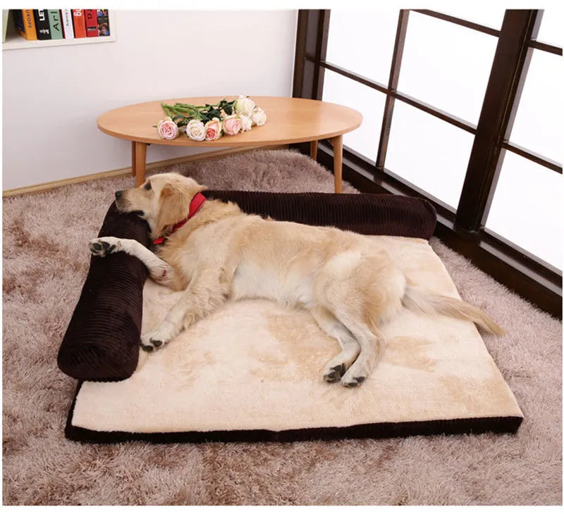 A corduroy dog sofa bed with a raised bolster side, shown in a grey colour on a wooden floor.