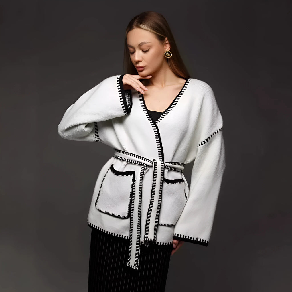 Lace-up front knitted cardigan in a camel colour, shown loose and open over a top.