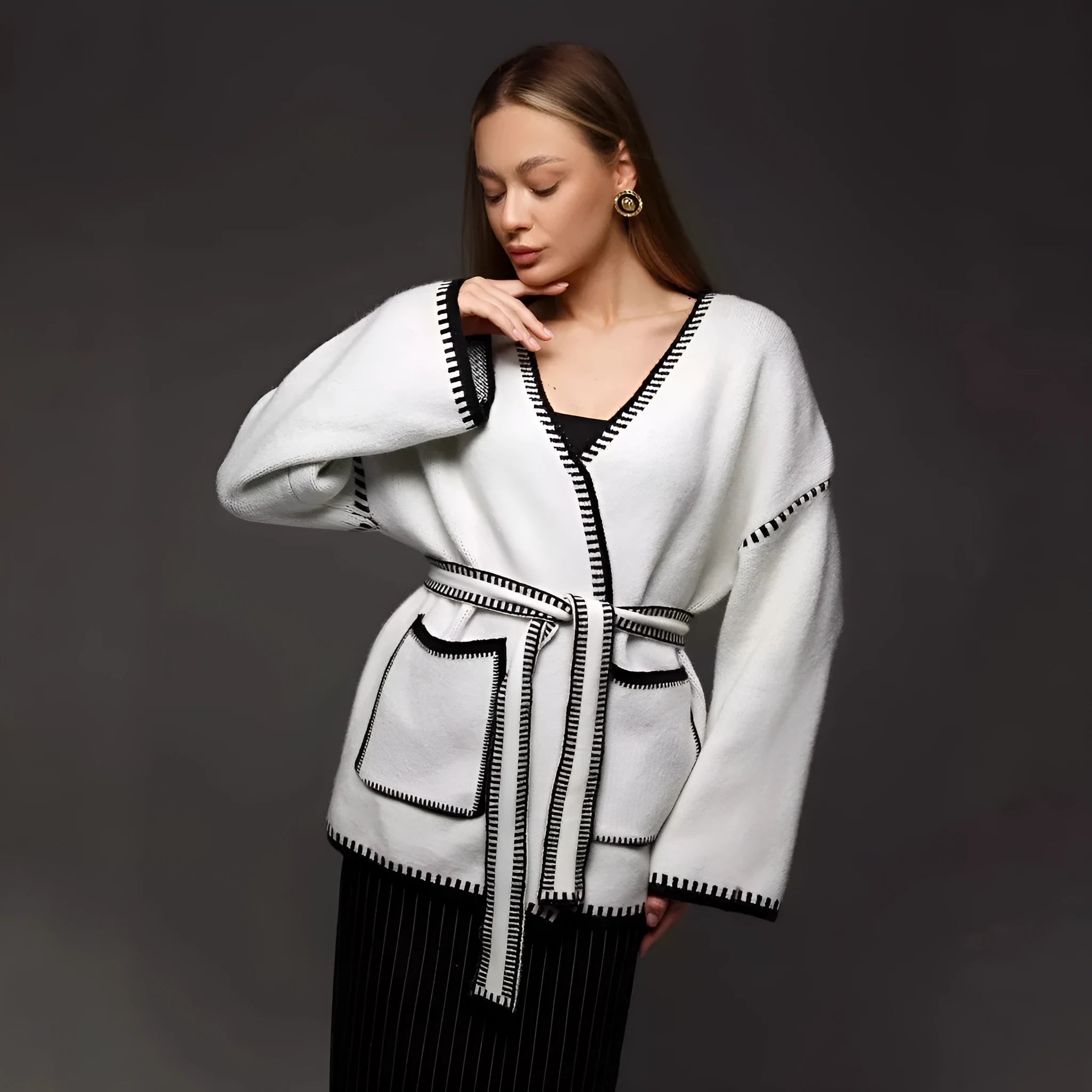 Lace-up front knitted cardigan in a camel colour, shown loose and open over a top.