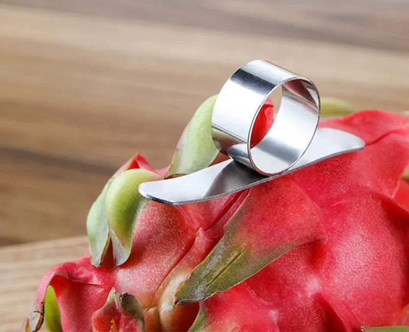 Silver stainless steel kitchen peeler tool with a finger ring for peeling oranges and citrus fruit.