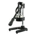 A tall black cast iron manual citrus juicer with a stainless steel strainer on a kitchen counter.
