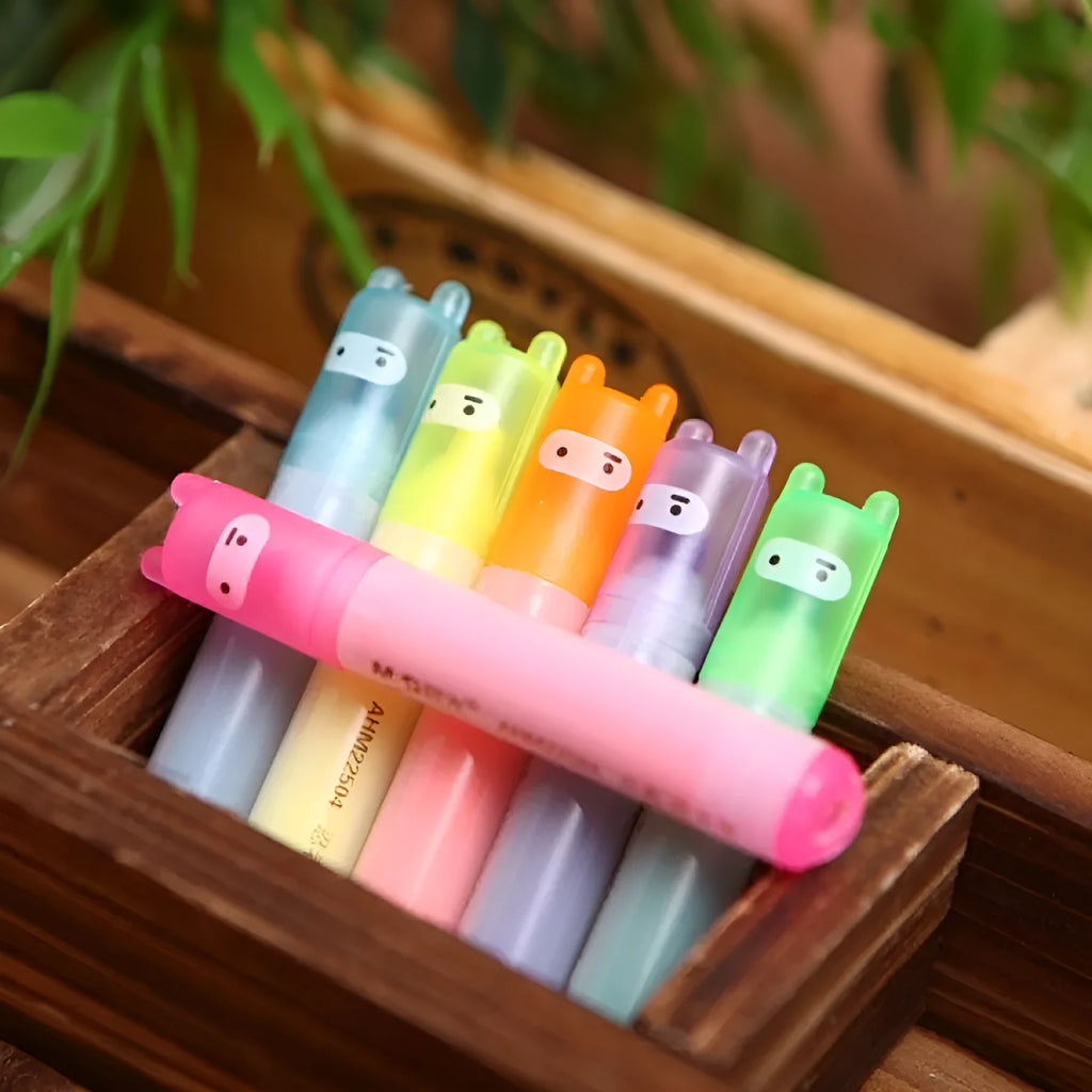 Set of six oblique highlighter pens with plastic shells in assorted colours, presented in a bag.