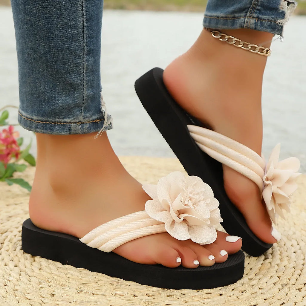 Women's beige flip-flops with a red flower decoration on the strap and a lightweight EVA sole.