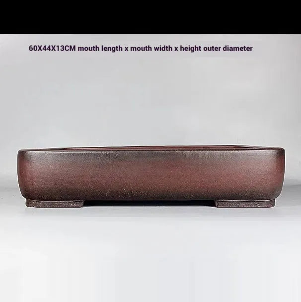 Handmade large rectangular purple clay flower pot for floor plants on a table.