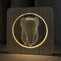 Wood colour tooth shaped acrylic night lamp with USB cable on wooden surface
