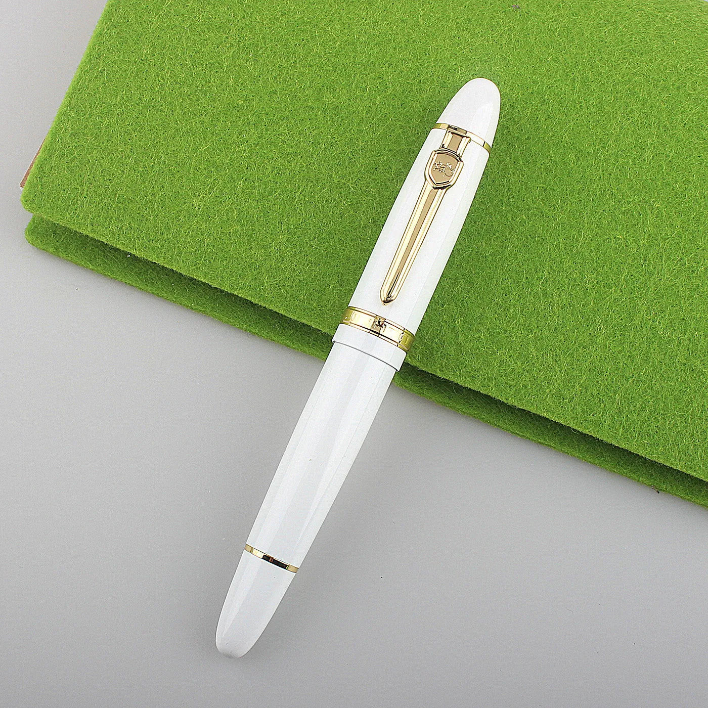 Metal ball pen with pearl beads, black body and silver clip, lying on a desk