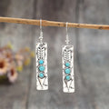 Silver long strip geometric earrings with turquoise inlay, showing front view.