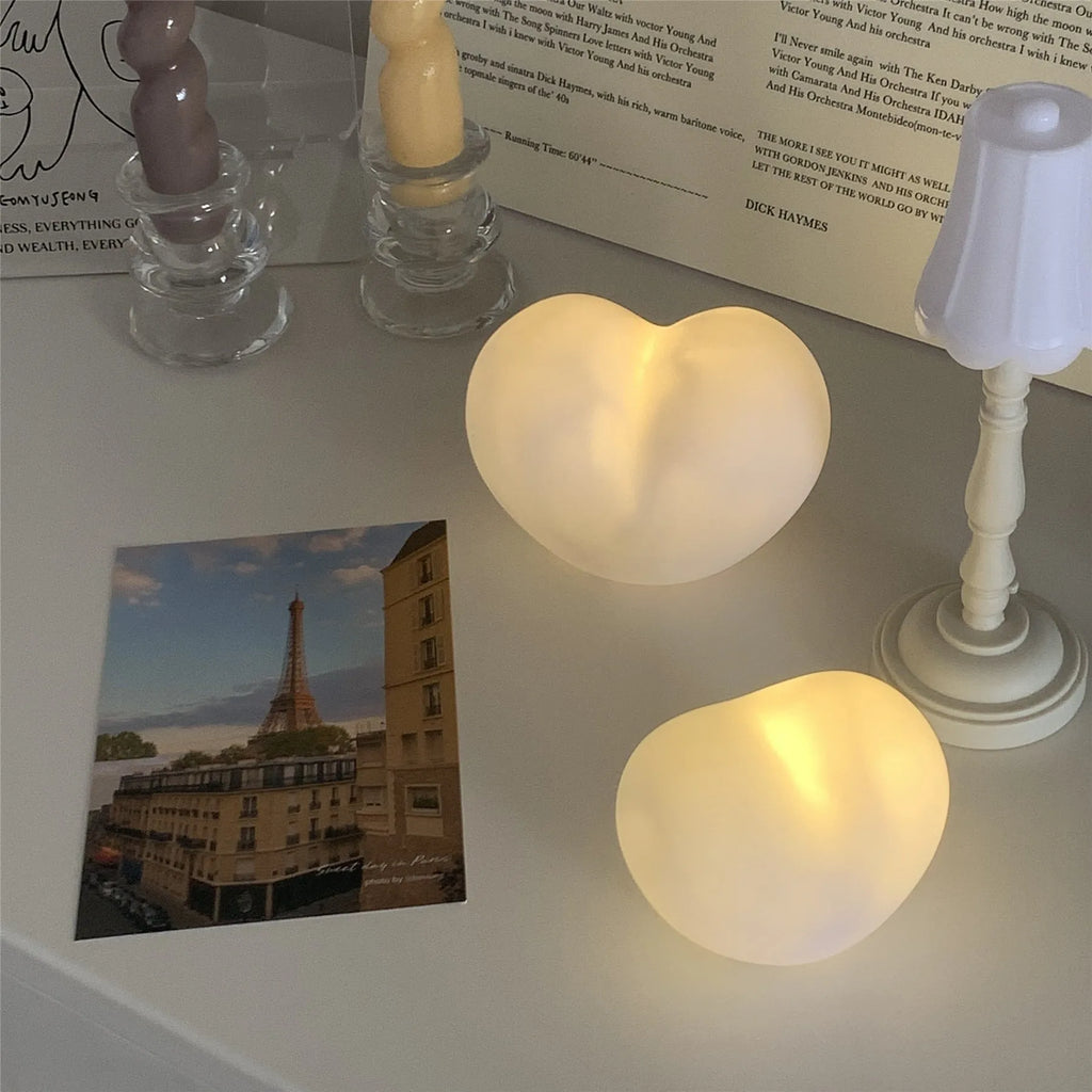 White and pink vinyl atmosphere lamp in trumpet and tuba shapes on a bedside table.