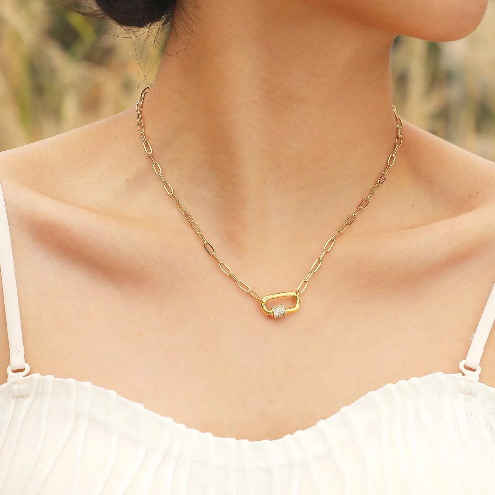 Gold electroplated stainless steel small square chain necklace with oval zircon pendant on a light background