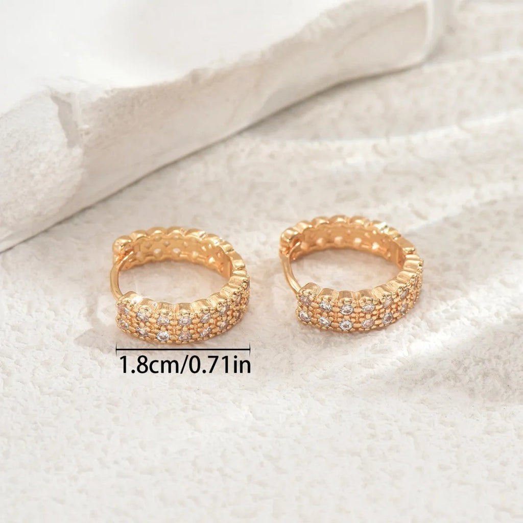 A pair of women's copper geometric ear studs with a dot and ring design, shown against a plain background.