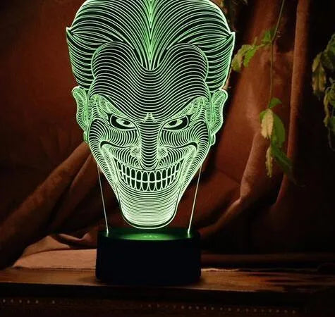 Compact USB-powered 3D LED desk lamp with a touch switch and remote control on a desk.