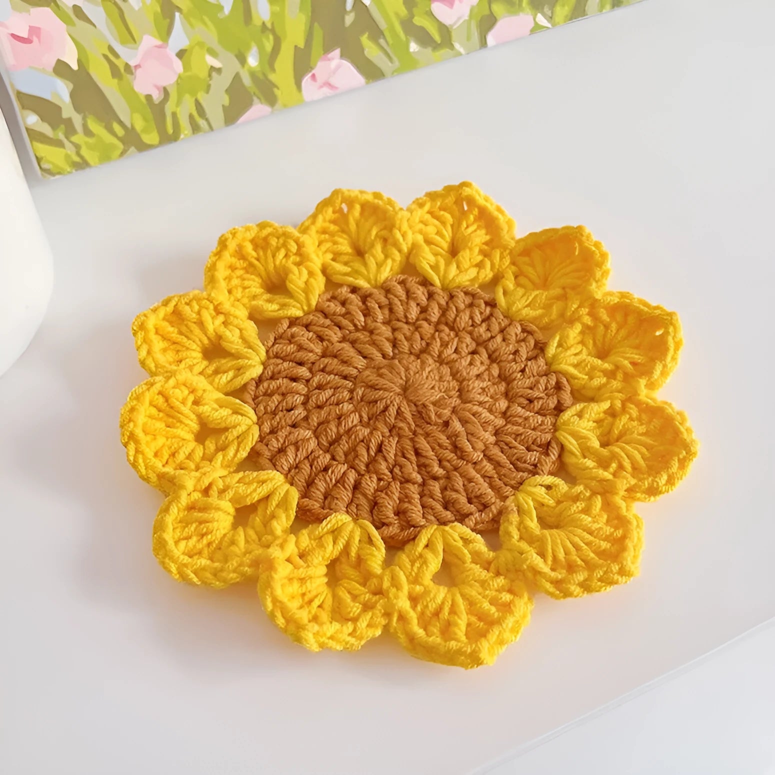Hand-woven circular wool coaster with floral pattern, 10.5cm diameter