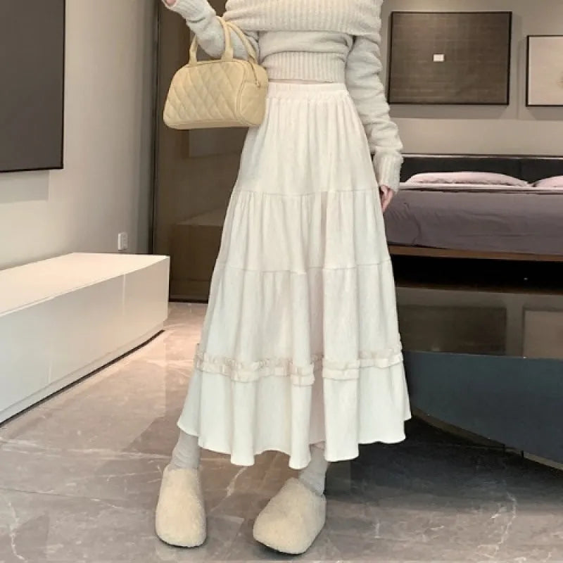 Beige corduroy A-line midi skirt with an elastic waistband laid flat.