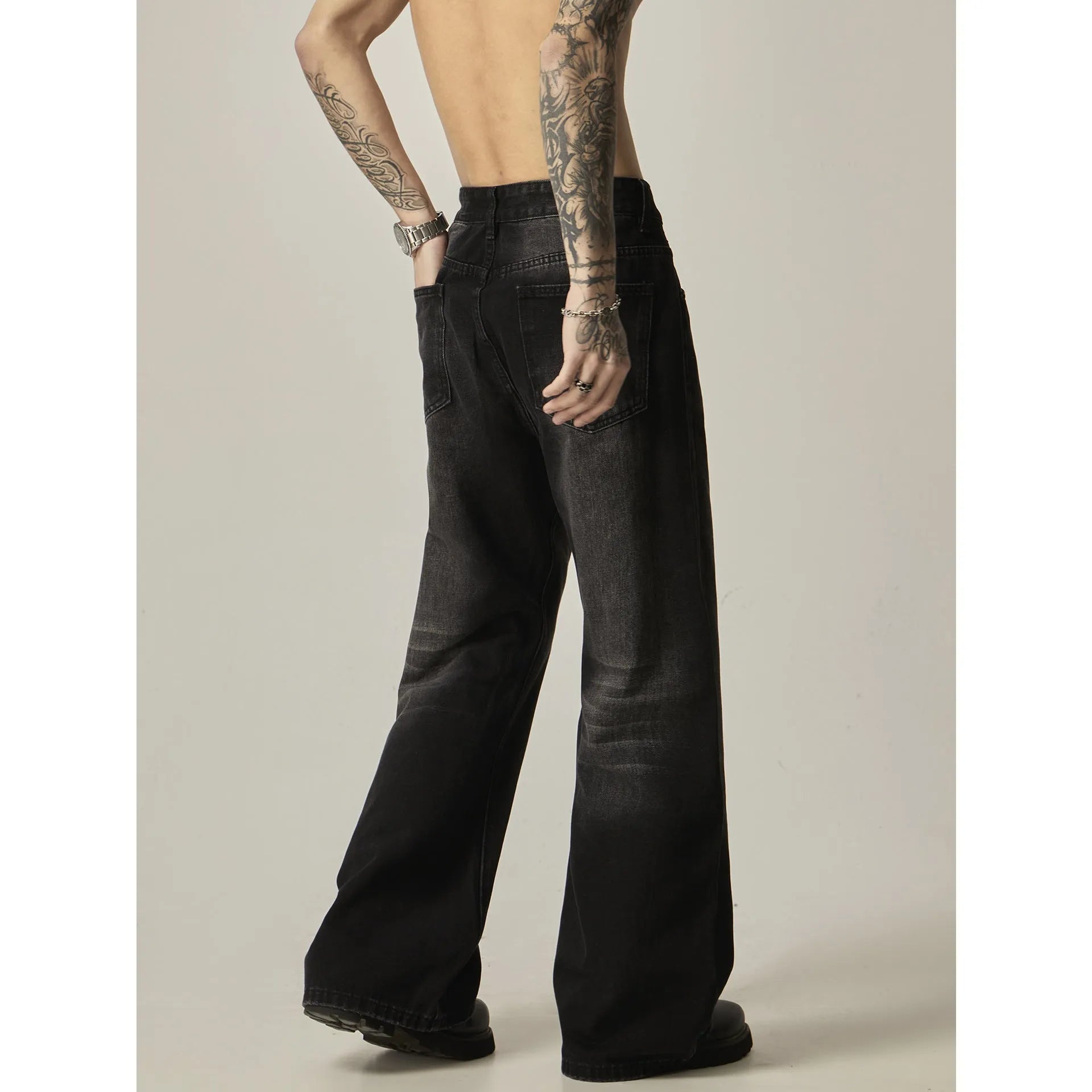 A pair of black loose-fit straight-leg jeans with a retro style on a white background.