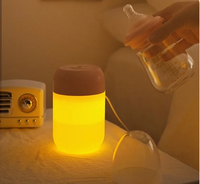 Small white cylindrical USB humidifier with aromatherapy diffuser on a wooden surface.