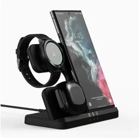 White vertical 3-in-1 wireless charging stand holding a mobile phone, a smartwatch, and wireless earbuds.
