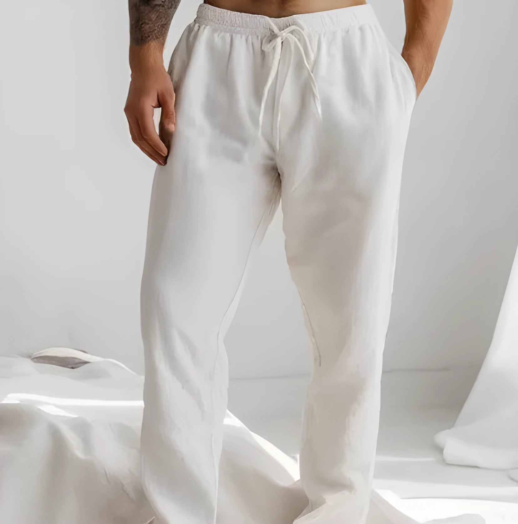 Men's light blue cotton linen loose-fit trousers with an elastic drawstring waist and straight legs.