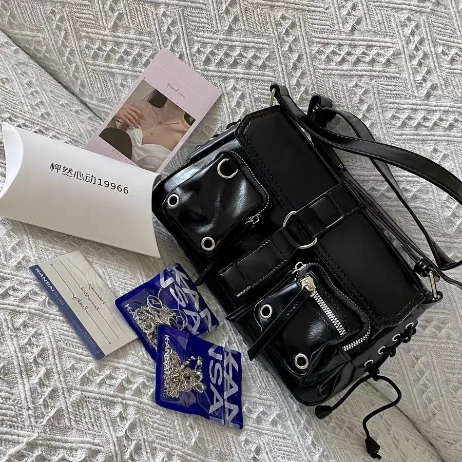 Black PU messenger bag with adjustable crossbody strap showing internal zipper change compartment