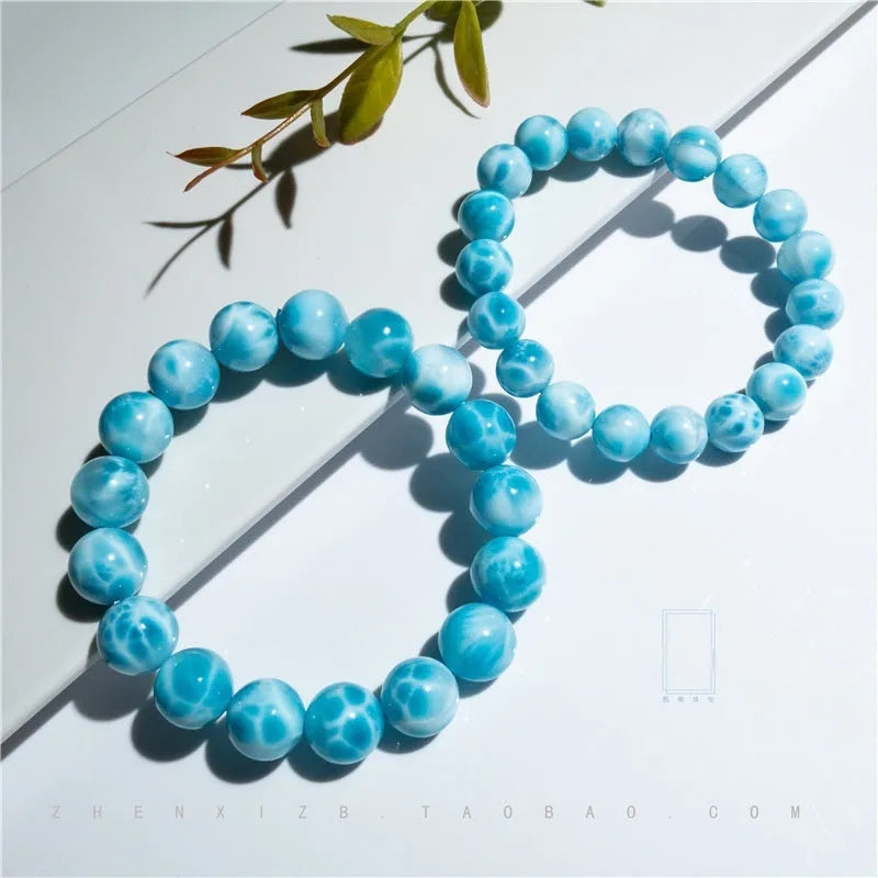 Blue natural crystal sea-pattern stone and Bodhi bracelet with pearl details on a white background.